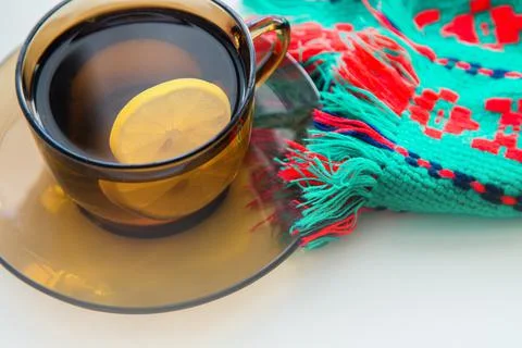 A dark transparent cup of tea with lemon stands on a dark saucer, next to it Foto stock