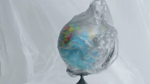 A dark trash bag develops on the globe stands among polyethylene Video stock 170160137