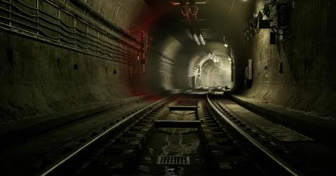Dark underground tunnel with train tracks and soft glowing lights at night Illustrazione stock