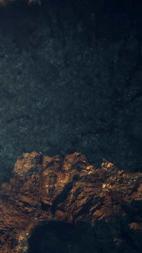 Dark underwater scene with rocky surfaces and light spots in the ocean Stock Footage 345009092