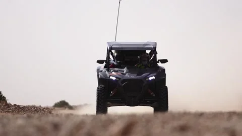 Dark UTV Off-Road Buggy With Flag Driving Towards Camera on Rocky Desert Stock Footage 332962953