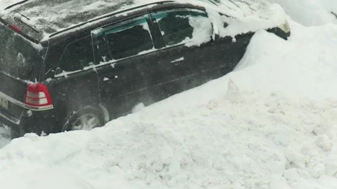 Dark vehicle attempts movement in deep fresh snow, wheels spinning, snow flying, Stock-Footage 342230969