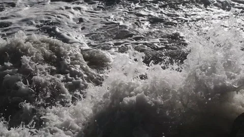 Dark video of dramatic ocean waves crashing against dark coastal rocks, creating Stock Footage 301920892