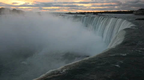 Dark view of Niagara Falls water in opposite to pink clouds of very early sun Stock Footage 55514255