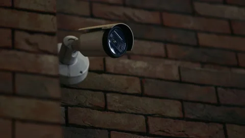 Dark view over a CCTV security camera mounted onto a brick wall Stock Footage 219867438