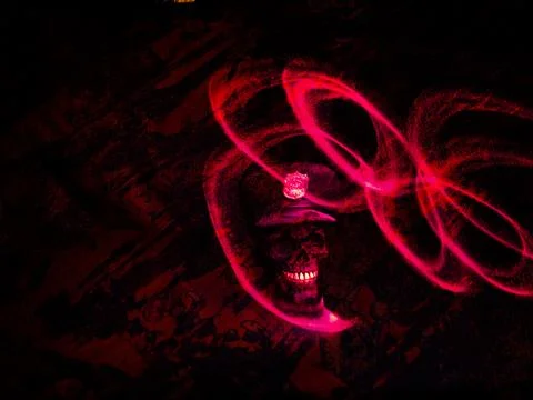 Dark visual with sharp red loops of light floating around a sinister skull Stock Photos