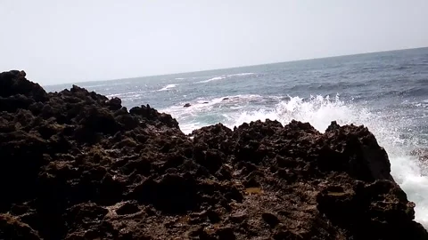 Dark Volcanic Coastal Rocks with Waves Breaking Beyond Stock Footage 342612629