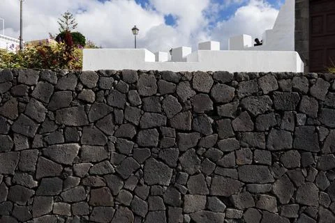 Dark volcanic stone wall texture with irregular pattern Stock Photos