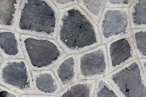 A dark wall made of angular stones Stock Photos