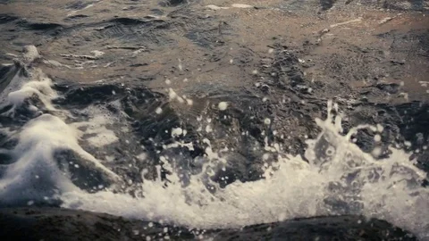 Dark water creates a wave on the rocks slow motion Video stock 81401889