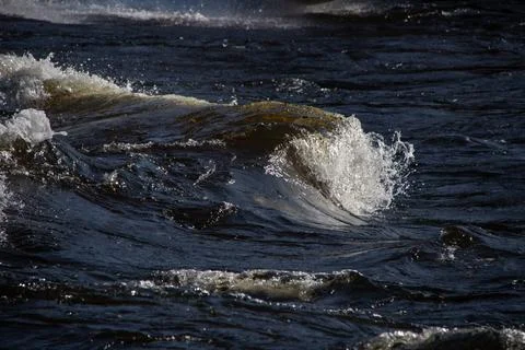 Dark water waves with white splashes close-up Stock Photos
