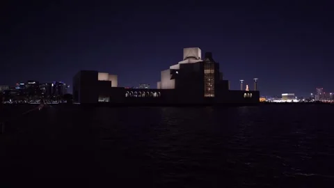 Dark waters reflect glowing city skyline at night 스톡 동영상 337763940