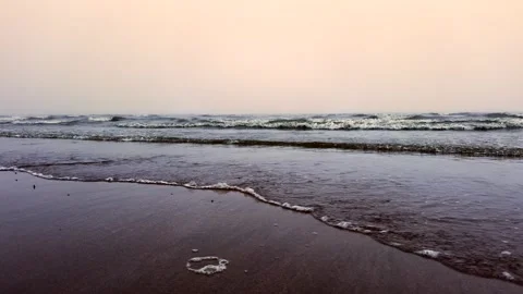 Dark waves roll toward shore under gloomy autumn sky. Cold wind shapes sea mood Stock Footage 314307791