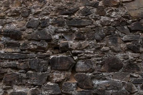 Dark Weathered Stone Wall Texture with Irregular Masonry Stock Photos