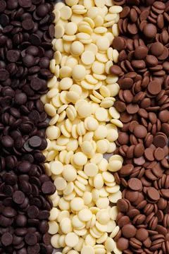 Dark, white and medium dark chocolate drops for making chocolate and candies as  Stock Photos