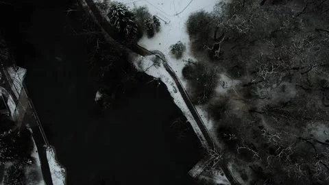 Dark Winter Drone Shot Over Snowy Park with Frozen Lake and Playground 4K Ae Stock Footage 313358530