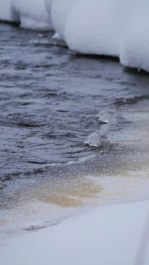 Dark Winter River Rippling Against Snowy Banks Vertical Slow Motion - Water Curr Stock Footage 326665843