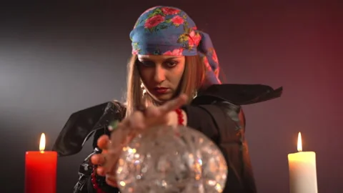 Dark witch moving hands above mystic crystal ball and spelling potion, gypsy Stockbeeldmateriaal 164662322