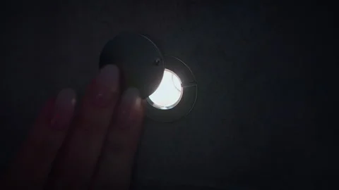 In the dark, women's fingers move the shutter of the door peephole, a close-up Stock Footage 306850198