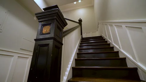 Dark wood staircase with white railing in a house Stock Footage 345690095