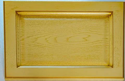 Dark yellow kitchen facade close-up. background of gilded wood textured decor Stock Photos