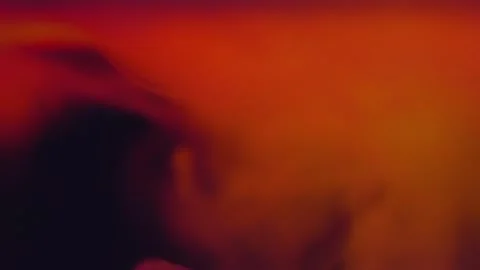 In the darkness, clouds of smoke move in a multi-colored glow Stock Footage 303175634