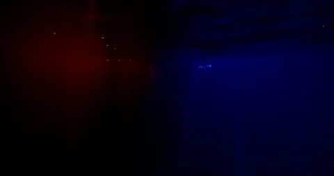 Darkness with red and blue rays of light. a woman in silver clothing falls under Stockbeeldmateriaal 123410396