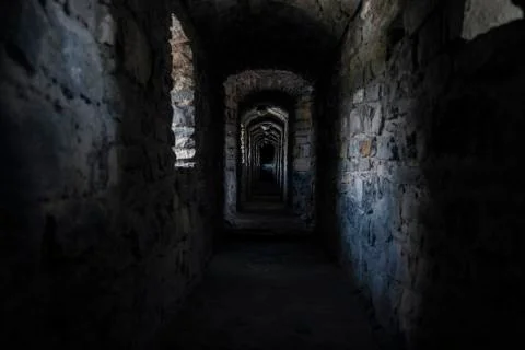 Darkness underground passage in cold medieval castle dungeon  Stock Photos