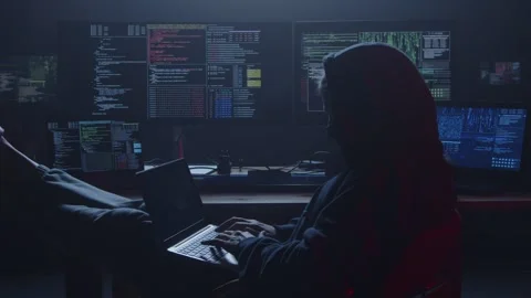 A darkroom hacker is engrossed in work, surrounded by multiple screens and code Stock Footage 281759462