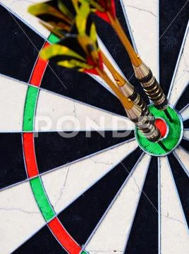Dart arrow hitting in the target center of dartboard. Stock Photos