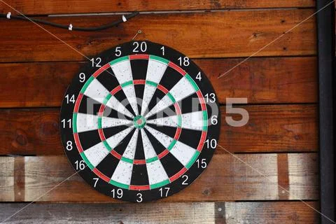Dart board on wood wall Stock Photos