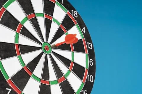 Dartboard on a blue background with arrows hitting the center target Stock Photos