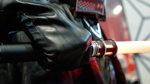 Darth Vader with red light stick sword in his hand at the cosplay expo in Video stock 221784751