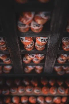 Daruma Dolls Viewed From Below on Dark Wooden Shelf Stock Photos