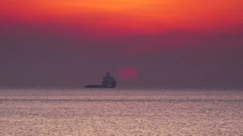 Darwin Sunset 9 ship passing setting sun Stock Footage 130766401