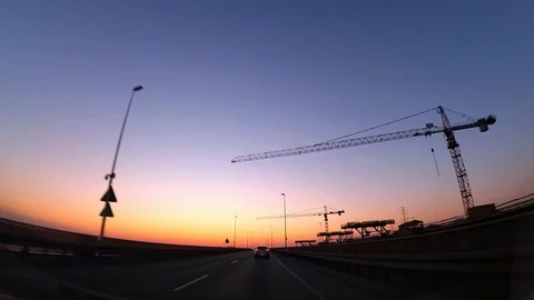 Dash Cam Driving Next to Construction Site and Cranes at Sunset POV Stock Footage 93187794