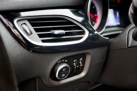 Dashboard headlight switch control panel with air vent in modern car interior Stock Photos
