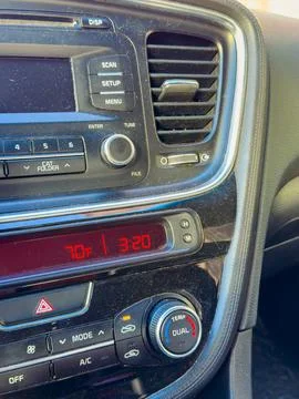 A dashboard shows the time as 3:20 and the temperature as 70F in a car. Contr Stock Photos