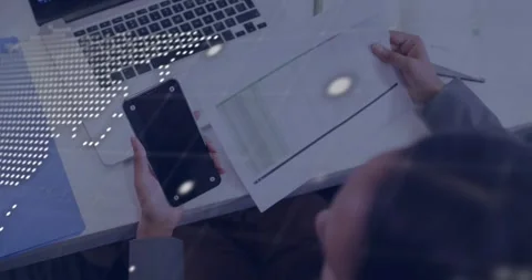 Data analyst aligning chart with smartphone data as world map overlay pulses Stock Footage 318260075