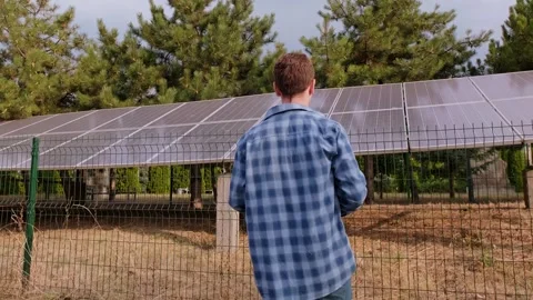 Data analyst and energy consultant standing with his back, analyzing solar syste Stock Footage 300250391