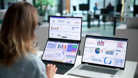 Data Analyst Carefully Reviews Financial Dashboard Metrics 動画素材 345855293