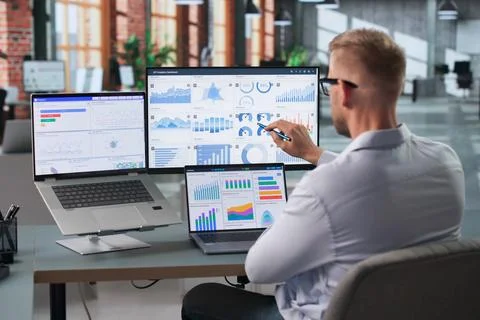 Data Analyst Focused On Reviewing Key Performance Indicators In Modern Office Stock Photos