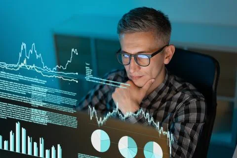 Data Analyst Reviewing Financial Graphs and Charts on Computer Screen Foto stock