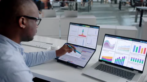 Data Analyst Reviewing High-performance Financial Dashboards Stock Footage 342977833