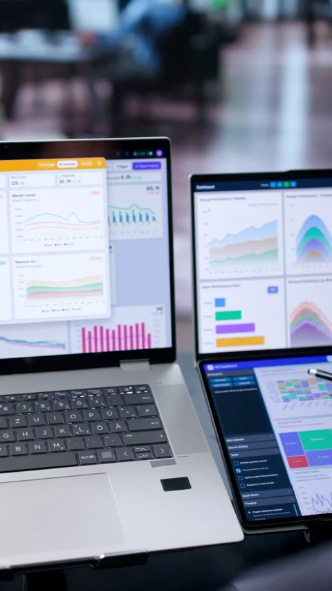 Data Analyst Reviews Financial Dashboards On Dual Touchscreen Laptops Stock Footage 340998470