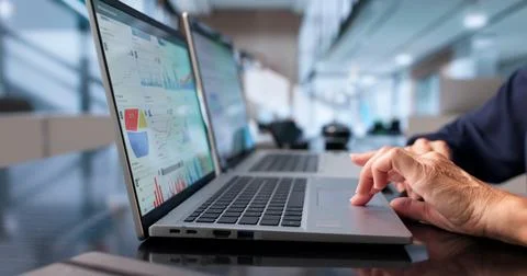 Data Analyst Studies Financial Dashboard Using Laptop For Market Insights. Stock Photos