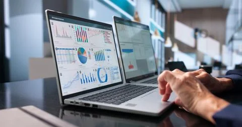 Data Analyst Studies Financial Dashboard On Laptop To Track Performance. Stock Photos