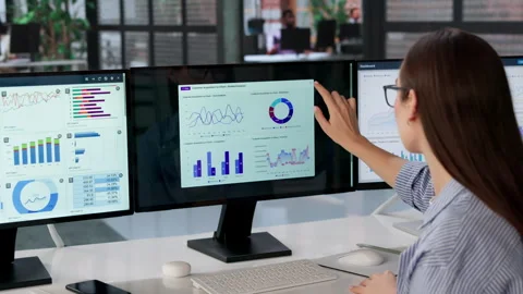 Data Analyst Studies Multiple Dashboards On Computer Screen Stock Footage 332910036