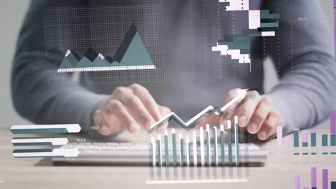 Data analyst tapping smartphone then typing at desk, animating bar charts for Stock Footage 334768804