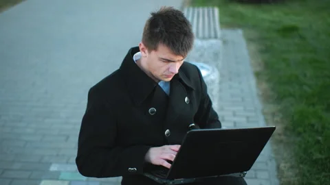 Data Analyst Typing on Laptop Outdoors with Grass and Paved Walkway Background 스톡 동영상 295880597